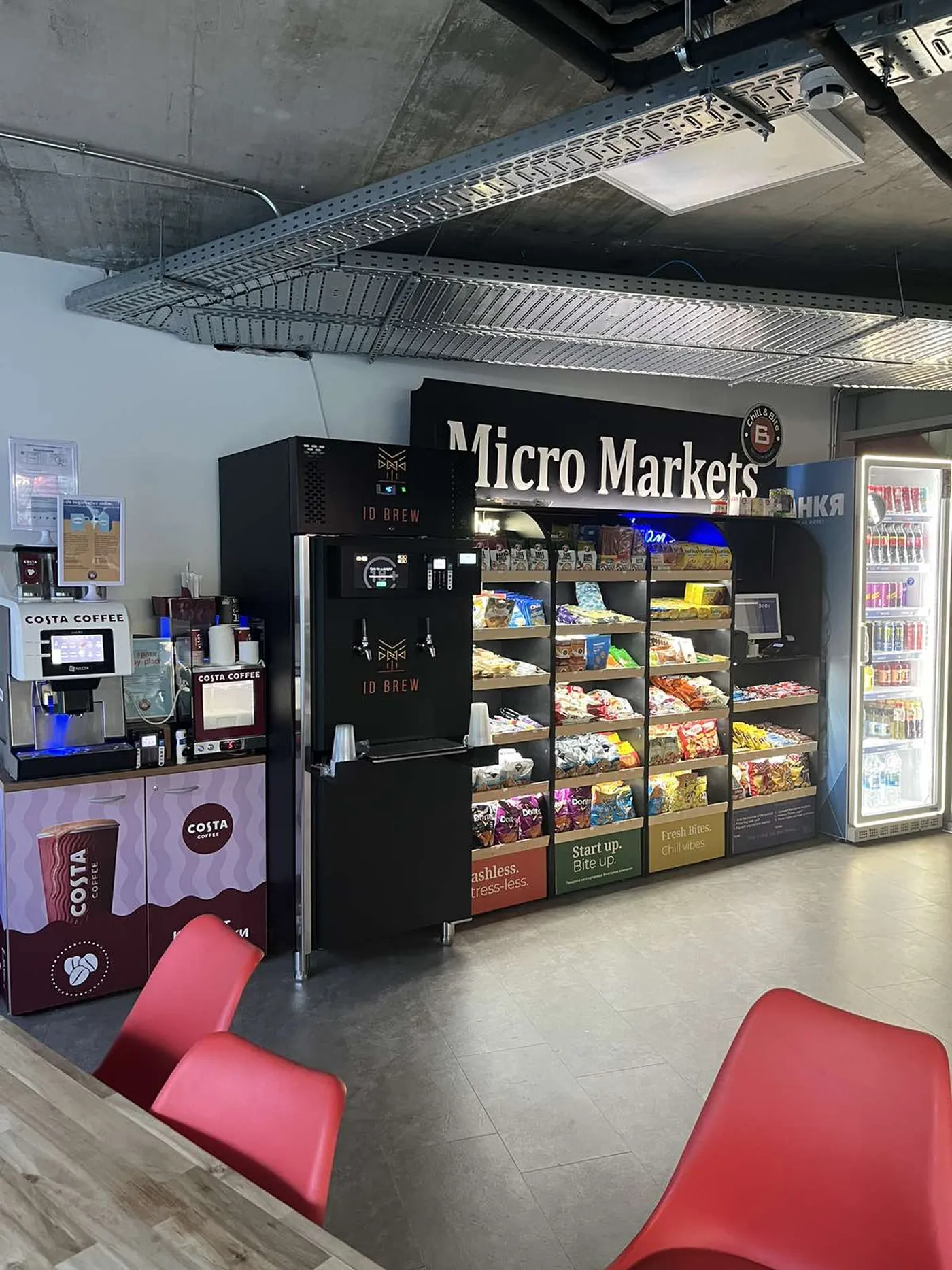 Chill&Bite Micro Market с рафтове със снаксове, хладилник с напитки, кафе машина и каса за самообслужване в офис сграда